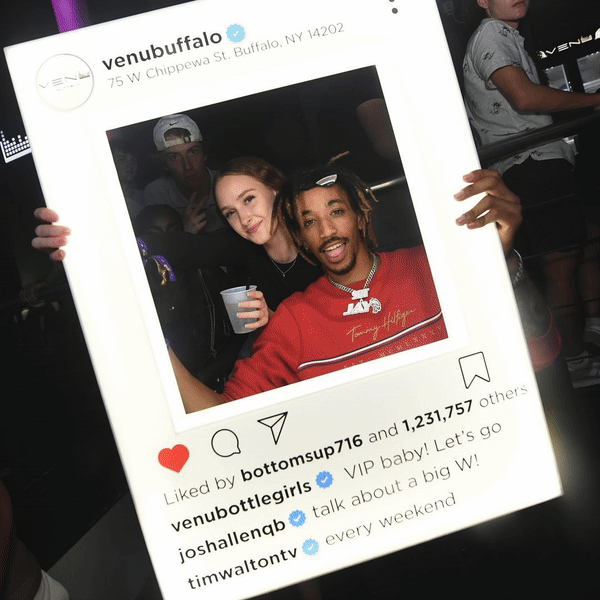 Nightclub patron holding a custom Instagram Presenter.